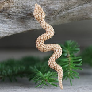 Long S-curve carved bone snake with scaled texture and antique stain, slender profile, no drill hole visible.