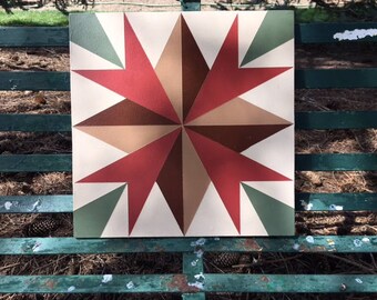 May include: A square tile with a geometric design featuring a starburst pattern in shades of red, brown, beige, and green. The tile has a white background.