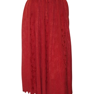 May include: A red midi skirt with an embroidered floral pattern and a scalloped hem. The skirt has an elastic waistband with a drawstring.