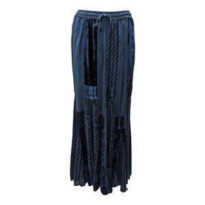 May include: A long, dark blue skirt with a textured, patterned design. The skirt has a drawstring waistband and a flowing, tiered silhouette.