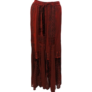 Puede incluir: Una falda larga de color burdeos con una superposición de encaje y una cintura con cordón.