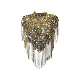 Può includere: Un top dorato con paillettes e frange. Il top ha un collo alto e una vestibilità ampia.