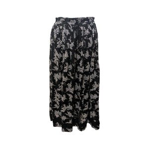 May include: A black maxi skirt with a white floral print. The skirt has an elastic waistband and a flowy silhouette.