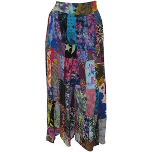 Może przedstawiać: Długa, wielokolorowa spódnica w stylu patchwork z różnymi wzorami kwiatowymi i geometrycznymi. Spódnica wykonana jest z miękkiej, przewiewnej tkaniny i ma wygodny elastyczny pas.