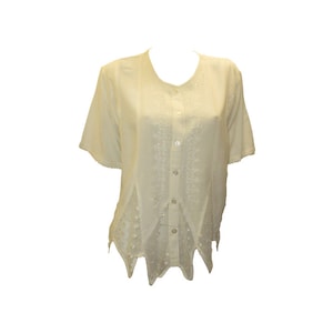 May include: A white, short-sleeved button-up blouse with a scalloped hem and delicate embroidery.