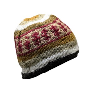 May include: A brown, white, and red striped knitted beanie hat with a geometric pattern.