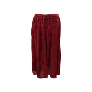 Può includere: Una gonna midi color bordeaux con vita a coulisse e dettagli ricamati.