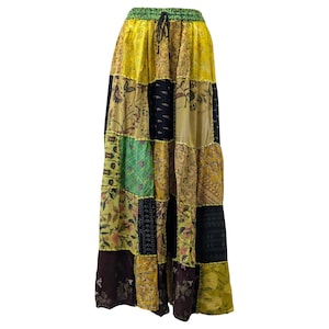 May include: A patchwork maxi skirt with a variety of floral and geometric patterns in shades of yellow, green, black, and brown. The skirt has an elasticated waistband with a drawstring. The skirt is made of a lightweight fabric.