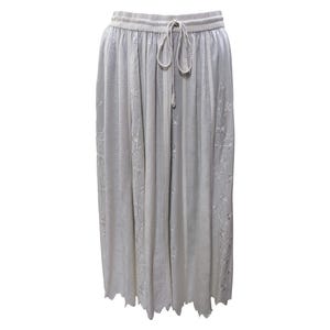May include: A light gray skirt with a drawstring waist and delicate floral embroidery. The skirt has a scalloped hem.