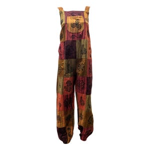 Può includere: Tuta patchwork nei toni dell'arancione, del rosso e del marrone. La tuta presenta una pettorina quadrata con un motivo a spirale e motivi floreali. Le cinghie sono larghe e i pantaloni sono ampi.