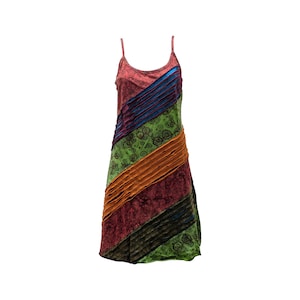 Puede incluir: Un vestido sin mangas y con tirantes finos. El vestido presenta rayas diagonales en tonos rojos, azules, verdes y naranjas. La sección verde tiene un estampado floral. El vestido está hecho de una tela suave y fluida.