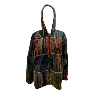 Può includere: Una giacca con cappuccio in patchwork con chiusura a zip. La giacca è realizzata con diversi tessuti in tonalità di marrone, verde, blu e rosso. Il tessuto presenta una varietà di motivi, tra cui strisce, paisley e motivi geometrici.