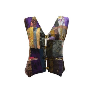 May include: A multi-colored patchwork vest with a V-neck and button closure. The vest is made of different fabrics and patterns, including floral, geometric, and paisley.