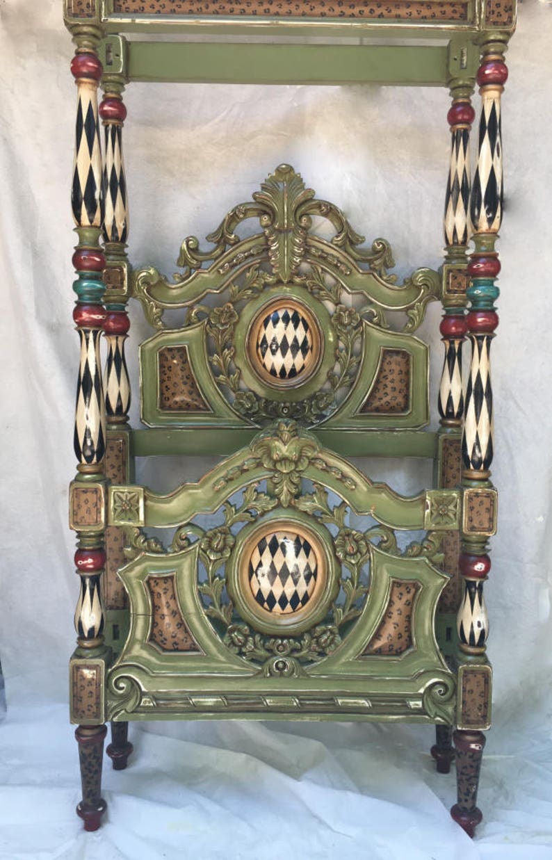 May include: Ornate, green four-poster bed frame with decorative carvings and patterned accents. The bed frame features black and white diamond patterns, red and teal accents, and leopard print details.