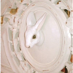 May include: White carved wooden headboard with a white rabbit figurine in an oval cutout.