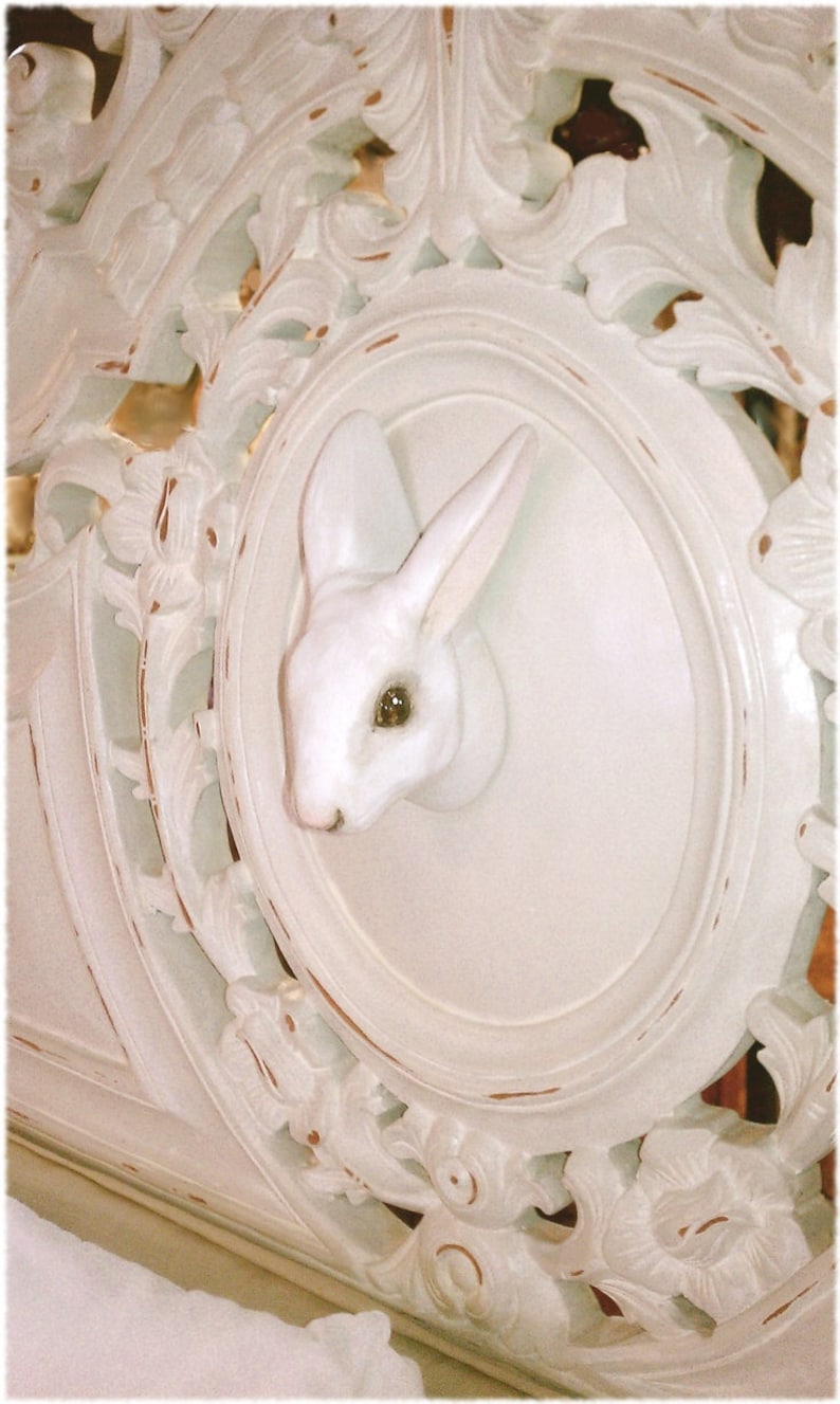 May include: White carved wooden headboard with a white rabbit figurine in an oval cutout.
