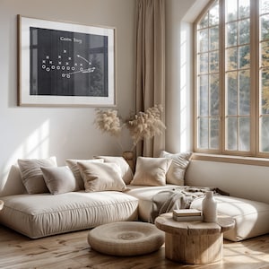Puede incluir: Un sof&aacute; seccional beige claro con varios cojines, una mesa de caf&eacute; de madera y un jarr&oacute;n con flores secas. El sof&aacute; est&aacute; en una sala de estar con una ventana grande y una pizarra enmarcada con una jugada de f&uacute;tbol dibujada en ella. La pizarra dice "Corn Dog".