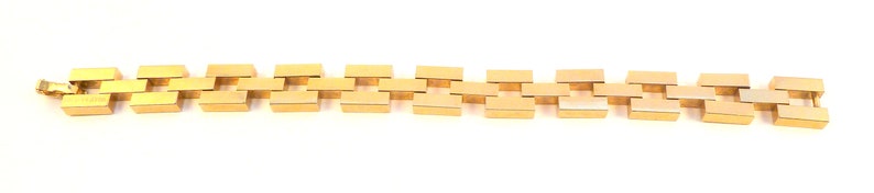 May include: A gold chain bracelet with a square link design.