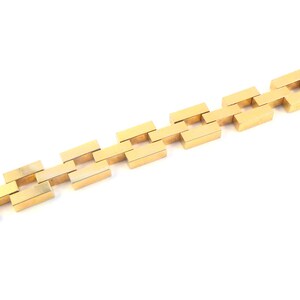 May include: A gold chain bracelet with a square link design.
