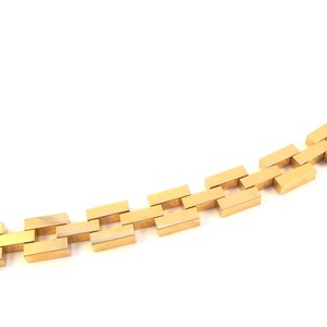 May include: A gold chain bracelet with a rectangular link design.