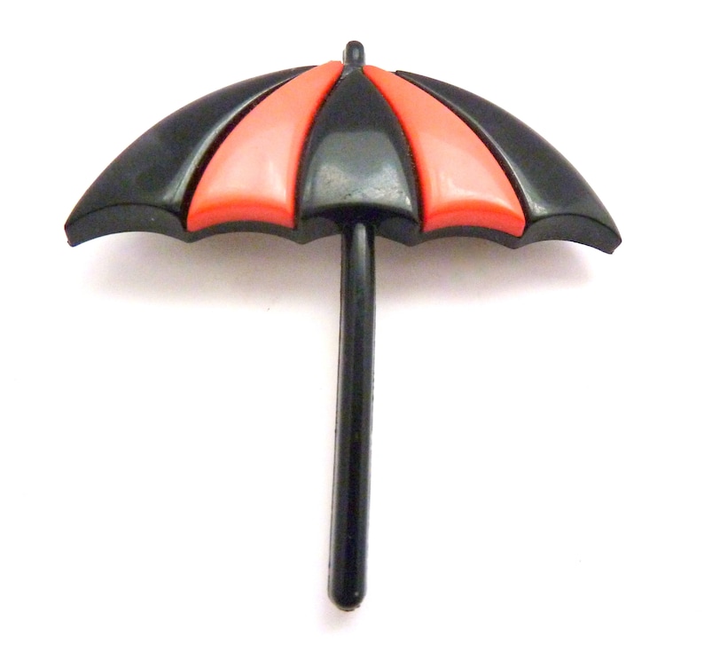 May include: A black and red plastic umbrella with a black handle. The umbrella is closed.