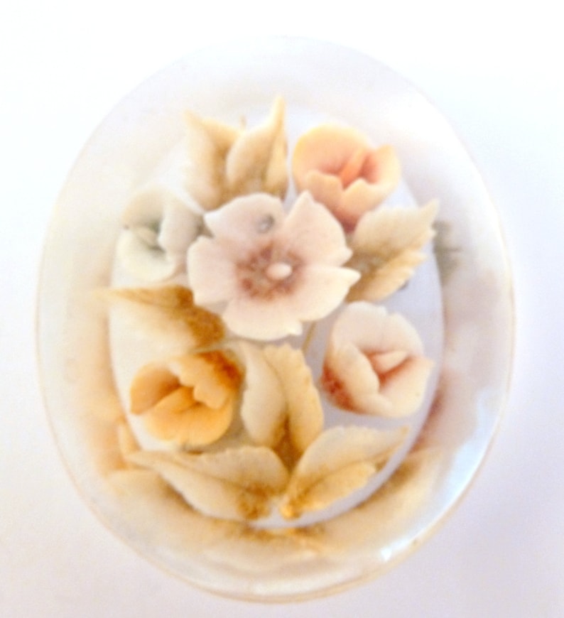 May include: A white ceramic dish with a floral design. The flowers are in shades of pink, orange, and white. The dish is decorated with gold accents.