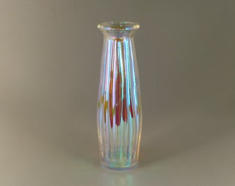 May include: A clear glass vase with iridescent stripes. The vase has a rounded bottom and a narrow opening.