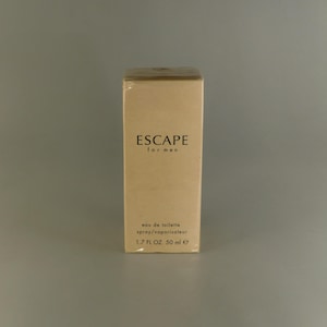 May include: A brown cardboard box with the text "ESCAPE for men" and "eau de toilette spray/vaporisateur 1.7 FL OZ 50 ml e" printed on it.