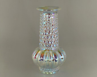 May include: Iridescent glass vase with a textured, bubble-like pattern on the cylindrical body. The vase has a bulbous base and a flared top. The glass reflects a rainbow of colors, creating a decorative and eye-catching piece.