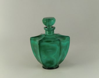 May include: A green glass bottle with a faceted design and a matching stopper. The bottle has a mottled green colour, reminiscent of malachite.