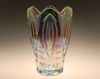 May include: A clear iridescent glass vase with a scalloped rim and a textured design. The vase has a rainbow effect.