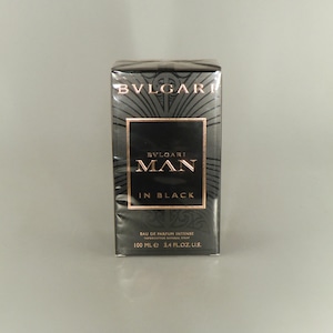 May include: A white ceramic mug with a black handle and the text "But First, Coffee" in a black, bold font. The mug is on a white surface. The mug is approximately 10 cm tall.