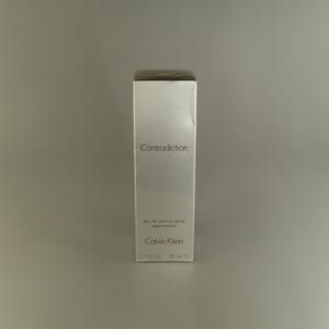 May include: A white box with the words "Contradiction" and "Calvin Klein" printed on it. The box contains a 50 ml bottle of eau de parfum spray.