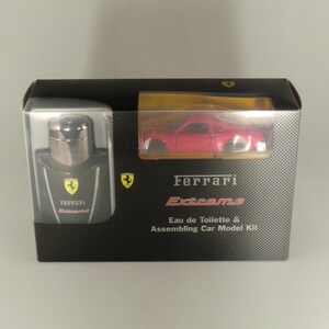 May include: A Ferrari Extreme gift set. The black box contains a bottle of Eau de Toilette and a red model car. The box has the Ferrari logo and the words "Extreme" and "Eau de Toilette & Assembling Car Model Kit".