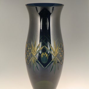 May include: A dark blue glass vase with a geometric pattern in shades of green and gold.