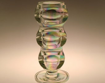 May include: A clear glass vase with a textured, iridescent surface. The vase has a round base and three bulbous sections.