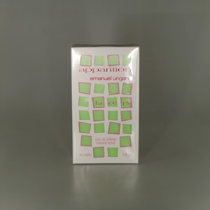 May include: A white box of "apparition" eau de toilette by Emanuel Ungaro. The box features green and pink accents, with the words "facets" and "eau de toilette natural spray". The box contains 90 ml or 3 fl oz.