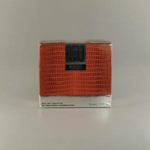 May include: A red and black Dunhill Pursuit Eau de Toilette spray bottle with a crocodile skin pattern. The bottle is 75 ml or 2.5 fl oz.