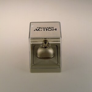 May include: A clear plastic box containing a silver perfume bottle. The box has the words "TRUSSARDI ACTION" printed on the top.