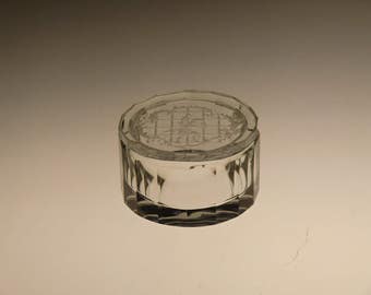 May include: A clear glass jar with a decorative etched design on the lid. The lid has a geometric pattern and a floral design.