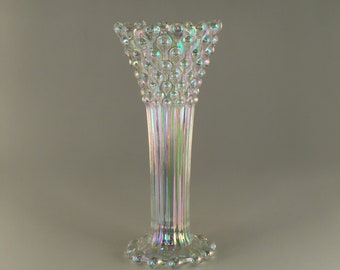 May include: A clear glass vase with a textured, iridescent finish. The vase has a wide, flared mouth and a narrow base.