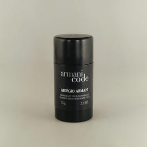 Puede incluir: Barra de desodorante negra con texto blanco "armani code" y "GIORGIO ARMANI". La etiqueta dice "DEODORANT STICK SANS ALCOOL ALCOHOL-FREE DEODORANT STICK" y pesa 75 g.