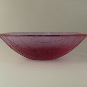May include: A frosted glass bowl with a pink hue and a geometric pattern.