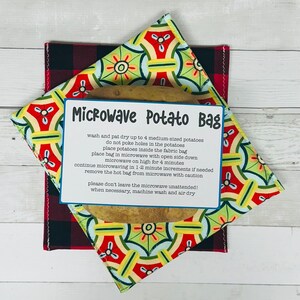 May include: A white card with the text "Microwave Potato Bag" and instructions for microwaving potatoes in a fabric bag. The card is on top of a red and green patterned fabric bag with a potato inside.
