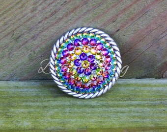 May include: A silver round buckle with a rainbow of rhinestones set in a rope design.