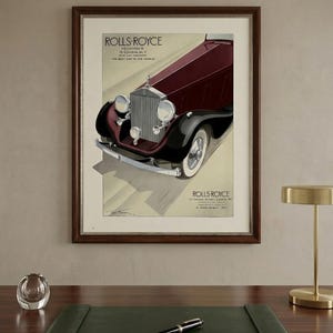 Könnte beinhalten: Gerahmte Vintage-Werbung für Rolls-Royce. Der Druck zeigt einen weinroten und schwarzen Oldtimer mit Weißwandreifen. Der Text lautet "ROLLS-ROYCE" und "DAS BESTE AUTO DER WELT". Der Rahmen ist dunkelbraun.