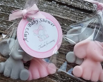May include: Two small elephant-shaped soaps, one pink and one gray, are packaged in clear cellophane bags with a pink and white tag that reads "Amy's Baby Shower Thanks for coming".