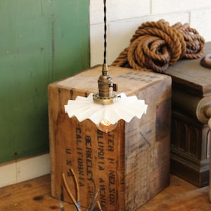 May include: A white ceramic mug with a black handle and the text "But First, Coffee" in a black, bold font. The mug is on a white surface.