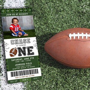 May include: A green and white ticket-style invitation for a first birthday party. The invitation features a photo of a baby boy wearing a red and white football jersey. The text on the invitation reads "Chase is turning one" and includes details about the party, including the date, time, and location. The invitation also includes a football graphic.