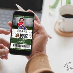 May include: A green and white football ticket invitation for a child's first birthday party. The invitation features a photo of a young boy wearing a football jersey and holding a football. The text on the invitation reads "Chase is turning one" and includes details about the party, such as the date, time, and location.